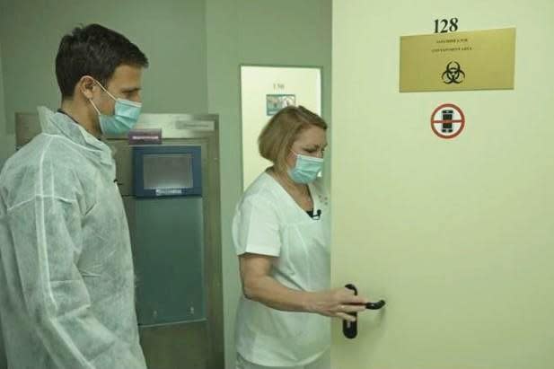 CBS News' Chris Livesay is led into Ukraine's Virology Reference Laboratory in Kyiv by Dr. Natalia Vidayko, the lab's chief researcher, May 2022. / Credit: CBS News