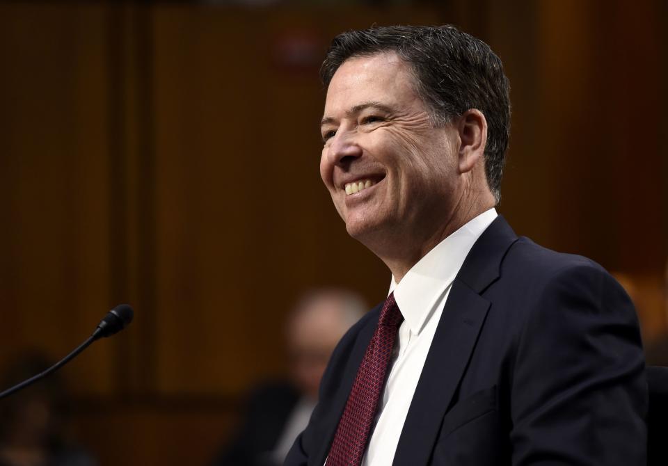 Comey laughs while testifying in a public hearing before the Senate Intelligence Committee the same day.