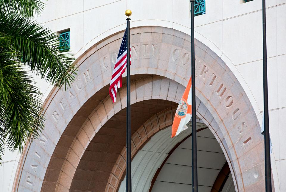 The flag at the Palm Beach County Courthouse flies high Wednesday, February 24, 2021 despite Gov. Ron DeSantis ordering that state and U.S. flags be flown at half-staff at the Palm Beach County Courthouse and Palm Beach Town Hall on Wednesday.  