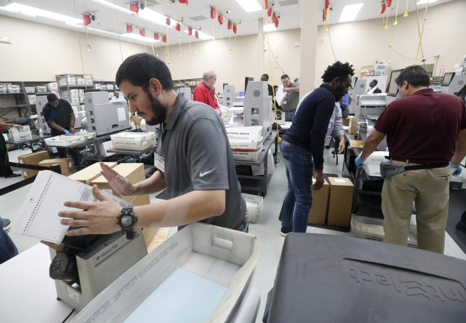 Employees at the Broward County elections office recount ballots Wednesday in Lauderhill, Fla. (Photo: Wilfredo Lee/AP)