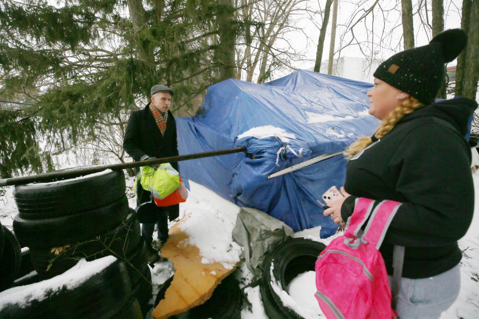 Zack Brown and Courtney Seymour of Community Support Services check on an empty camp during the 2024 Homeless Point in Time Count on Jan. 23 in Akron.