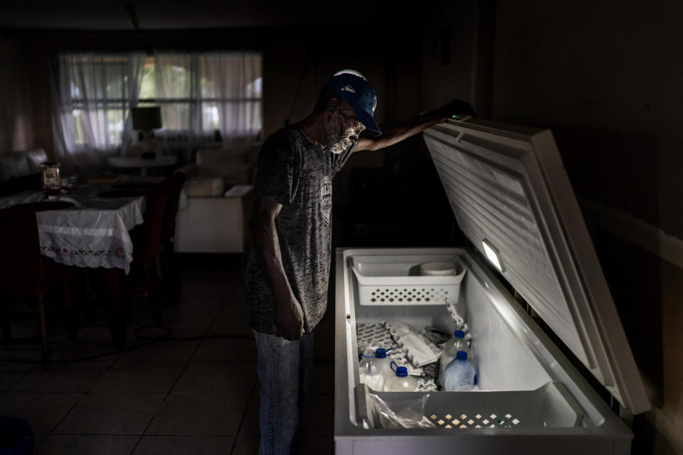 Leroy Glinton looks inside his fish freezer at his home in McLean's Town, Grand Bahama Island, Bahamas, Saturday, Dec. 3, 2022. Many local fishermen fish for other species, such as snapper, but, like Glinton, identify first as conch fishers. And for many, fishing is both a family tradition and a ticket to middle class life on the chain of islands, where the cost of living is a bit higher than in the U.S. (AP Photo/David Goldman)