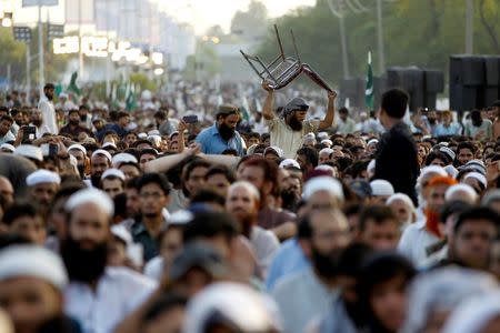 Supporters of the banned Islamic charity Jamat-ud-Dawa carry a chair through the crowd during a protest which Pakistani broadcast media were forbidden to cover in Islamabad, Pakistan, July 20, 2016. Picture taken July 20, 2016. REUTERS/Caren Firouz