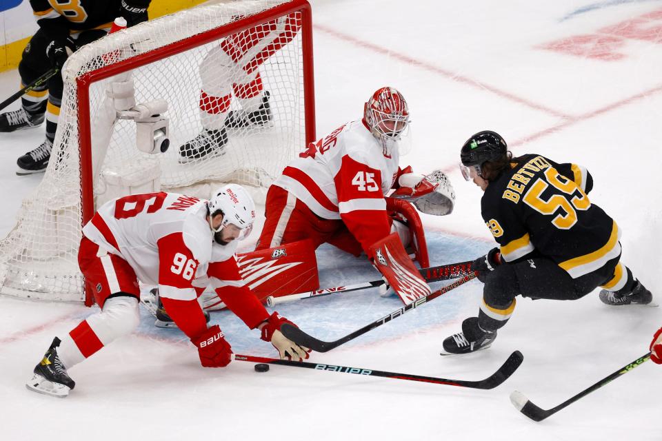 Detroit Red Wings defenseman Jake Walman (96) clears the puck away from the goal ahead of goaltender Magnus Hellberg as Boston Bruins left wing Tyler Bertuzzi looks on during the second period at TD Garden in Boston on Saturday, March 11, 2023.