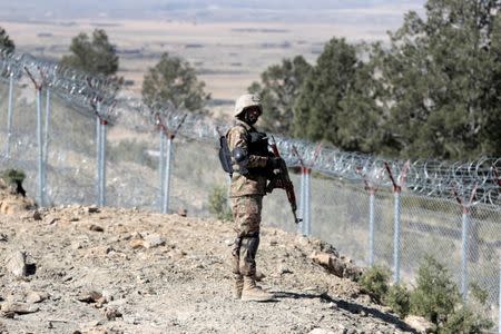 A soldier stands guard along the border fence at the Angoor Adda outpost on the border with Afghanistan in South Waziristan, Pakistan October 18, 2017. REUTERS/Caren Firouz