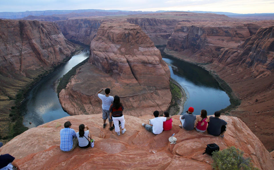FILE - In this Sept. 9, 2011 file photo visitors view the dramatic bend in the Colorado River at the popular Horseshoe Bend in Glen Canyon National Recreation Area, in Page, Ariz. Some 40 million people in Arizona, California, Colorado, Nevada, New Mexico, Utah and Wyoming draw from the Colorado River and its tributaries. Much of that originates as snow. A wet winter likely will fend off mandated water shortages for states in the U.S. West that rely on the river but won't erase the impact of climate change. Climate change means the region is still getting drier and hotter. (AP Photo/Ross D. Franklin, File)