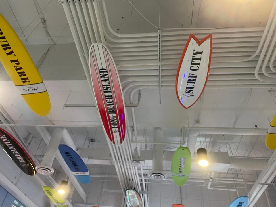 Surfboards with Jersey town names hang from the arcade ceiling.