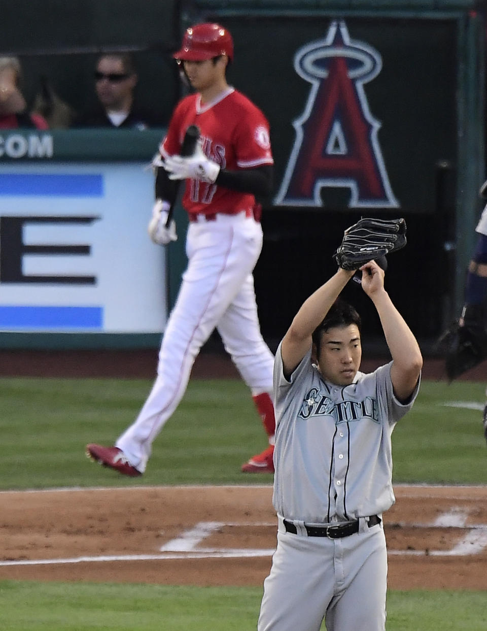 Seattle Mariners starting pitcher Yusei Kikuchi, right, wipes his face before pitching to Los Angeles Angels' Shohei Ohtani during the first inning of a baseball game Saturday, June 8, 2019, in Anaheim, Calif. (AP Photo/Mark J. Terrill)