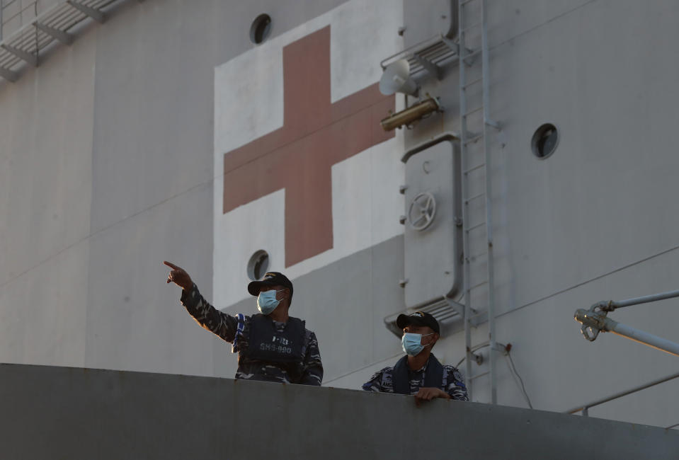 Members of Indonesian stand on its hospital ship KRI Dr. Soeharso as it prepares to join the search for submarine KRI Nanggala that went missing while participating in a training exercise, off Banyuwangi, East Java, Indonesia, Saturday, April 24, 2021. The Indonesian submarine went missing after its last reported dive Wednesday off the resort island, and concern is mounting it may have sunk too deep to reach or recover in time. (AP Photo/Achmad Ibrahim)