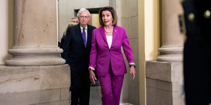 Mitch McConnell walking behind Nancy Pelosi