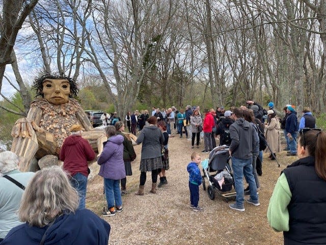 A crowd of about 100 gathered around Ninigret Park's first troll, waiting for artist Thomas Dambo to ride up on his bicycle for the official unveiling Friday.