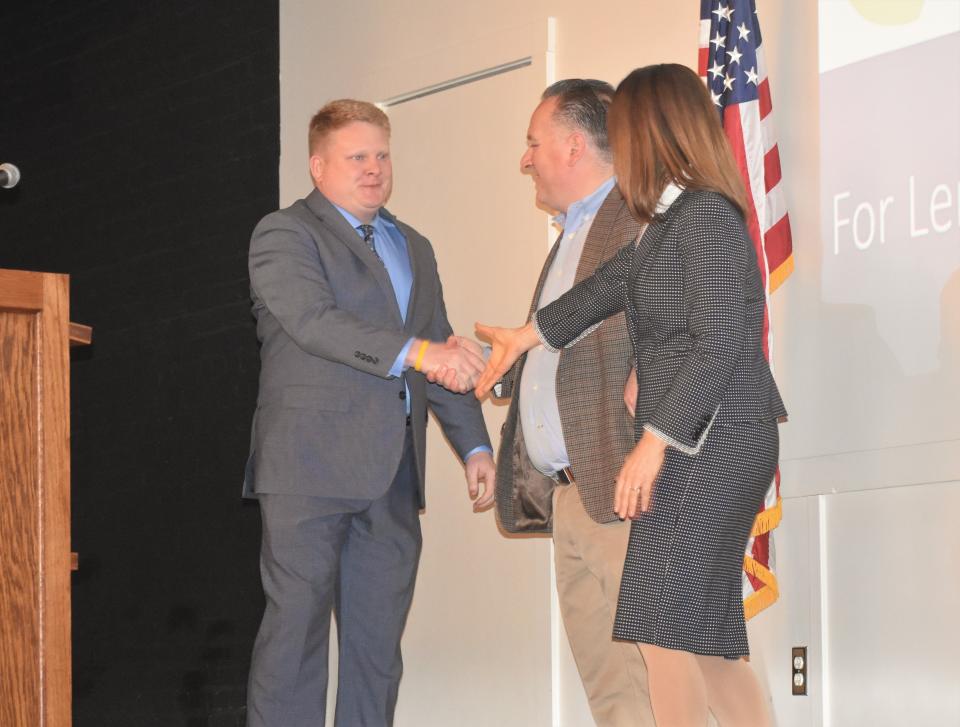 Austin See of Tecumseh, left, takes the stage at the Adrian Armory Events Center and is congratulated by Dave Herriman and Bronna Kahle, president and CEO of the Lenawee Community Foundation, after being named the 2023 recipient of the foundation's Incito Award during the foundation's annual meeting Thursday, April 27, 2023.
