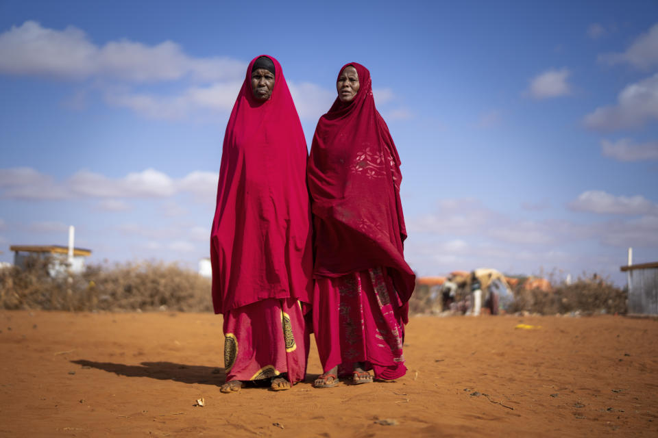 Abdiyo Barre Ali, right and Abdiyo Ali Abdi recite poetry at a camp for displaced people on the outskirts of Dollow, Somalia, on Wednesday, Sept. 21, 2022. Somalia is in the midst of the worst drought anyone there can remember. A rare famine declaration could be made within weeks. Climate change and fallout from the war in Ukraine are in part to blame. (AP Photo/Jerome Delay)