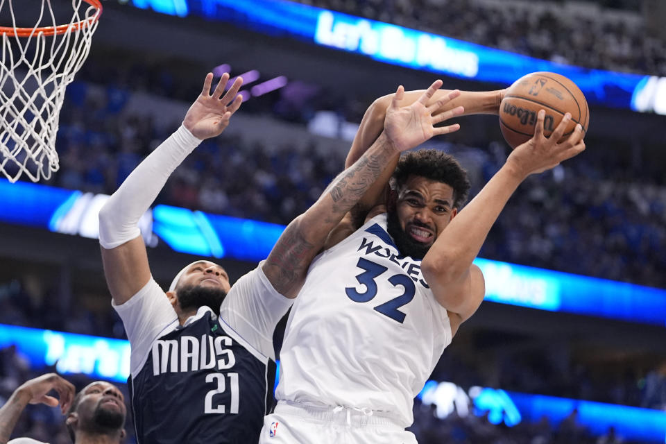 Minnesota Timberwolves center Karl-Anthony Towns (32) grabs a rebound over Dallas Mavericks center Daniel Gafford (21) during the second half in Game 3 of the NBA basketball Western Conference finals, Sunday, May 26, 2024, in Dallas. (AP Photo/Julio Cortez)