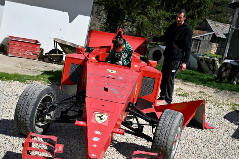 Himzo Beganovic y su hijo Bibo, de seis años, muestran su réplica del coche de carreras Ferrari el 4 de abril de 2024 cerca de la localidad borsnia de Kljuc (Elvis Barukcic)