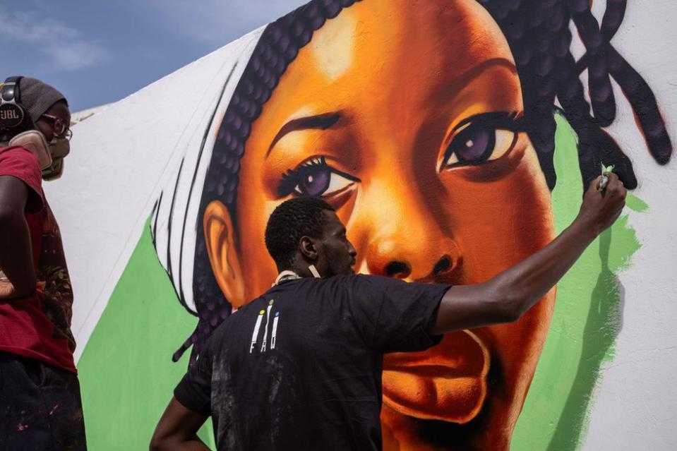 Graffiti artists, members of the Panafrican graffiti artists group RBS paint a fresco on the wall of the hospital in Popenguine, Senegal, 16 December 2023. The fresco is part of the Askan Wi Festival, organised by the association Wakh'Art, and aims at raising awareness about breast, cervical and prostate cancers by using culture as a lever for social cohesion and public health.