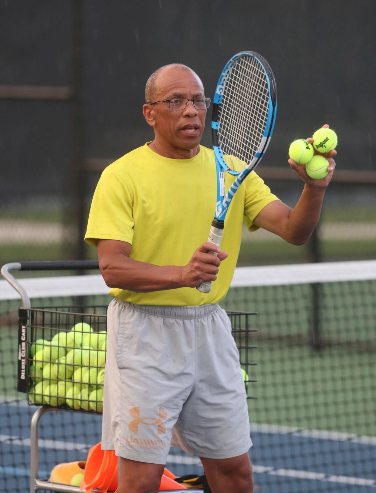 Jeff Collins gives tennis lessons to a small group of adults at the Palmer Park courts in Detroit on Aug. 18, 2022. Collins is using teaching tennis as a way to celebrate his late wife of 36 years, Lois Collins.