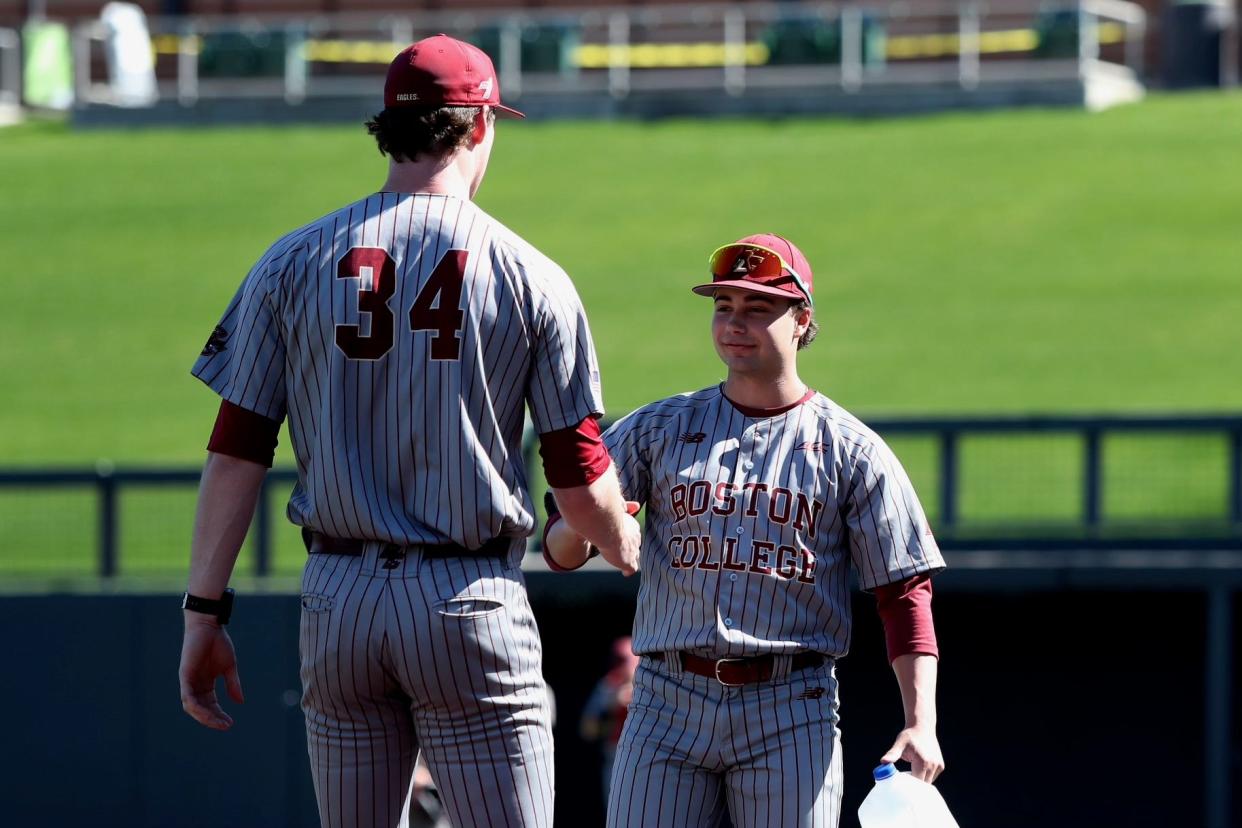 Best friends John West, left, and Tyler Mudd, right, meet at the mound during a recent game for Boston College.