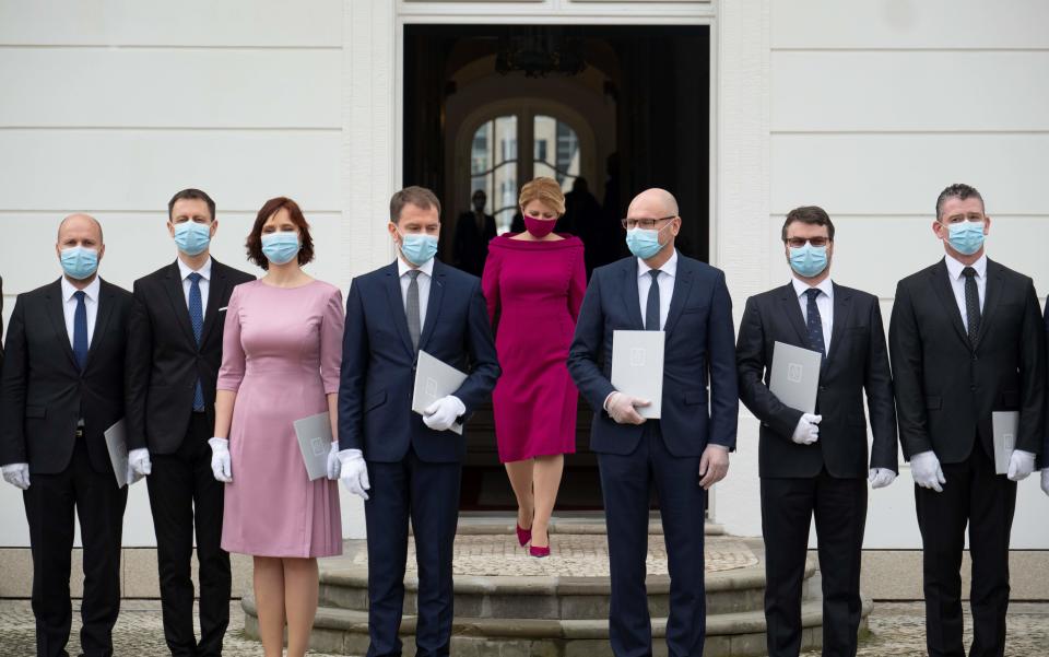 Slovak President Zuzana Caputova (C) arrives for a family picture with Ministers of the new four-party coalition government after a swearing in ceremony on March 21, 2020 outside the Presidential palace in Bratislava. - The ceremony was held without members of the press and all appointed government members wore gloves and face mask to prevent the spread of novel coronavirus. (Photo by JOE KLAMAR / AFP) (Photo by JOE KLAMAR/AFP via Getty Images)