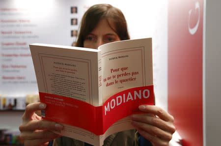 A woman reads a copy of a book by Nobel prize winner Patrick Modiano at the book fair in Frankfurt Ocotber 9, 2014. REUTERS/Ralph Orlowski
