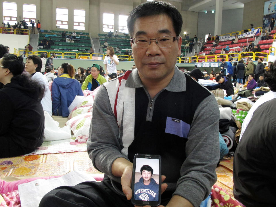 Lee Jong-eui, 48, shows a photo of his nephew Nam Hyun-chul,17, one of missing passengers aboard the ferry Sewol sank off South Korea, during an interview at a gymnasium in Jindo, South Korea Saturday, April 19, 2014. Relatives of about 270 people missing have grown increasingly exasperated and distrusting of South Korean authorities, in part because of confusion, early missteps and perceived foot-dragging. For days, they have dealt with shock, fear and bewilderment. They have briefly been buoyed by new ideas for finding survivors, changes in death counts and the number of missing, even rumors of contact with trapped relatives, only to be let down later. (AP Photo/Gillian Wong)