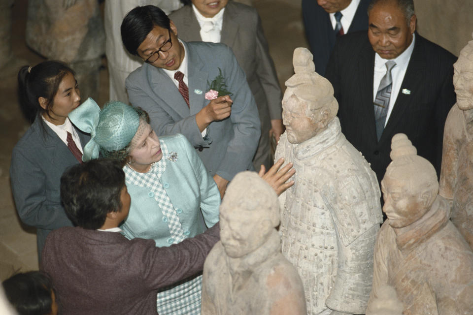 <p>The Queen inspects the Terracotta Army Xi'an during an official state visit to China on 16 October 1986, when she became the first ever British monarch to visit the country. (Tim Graham Photo Library via Getty Images)</p> 