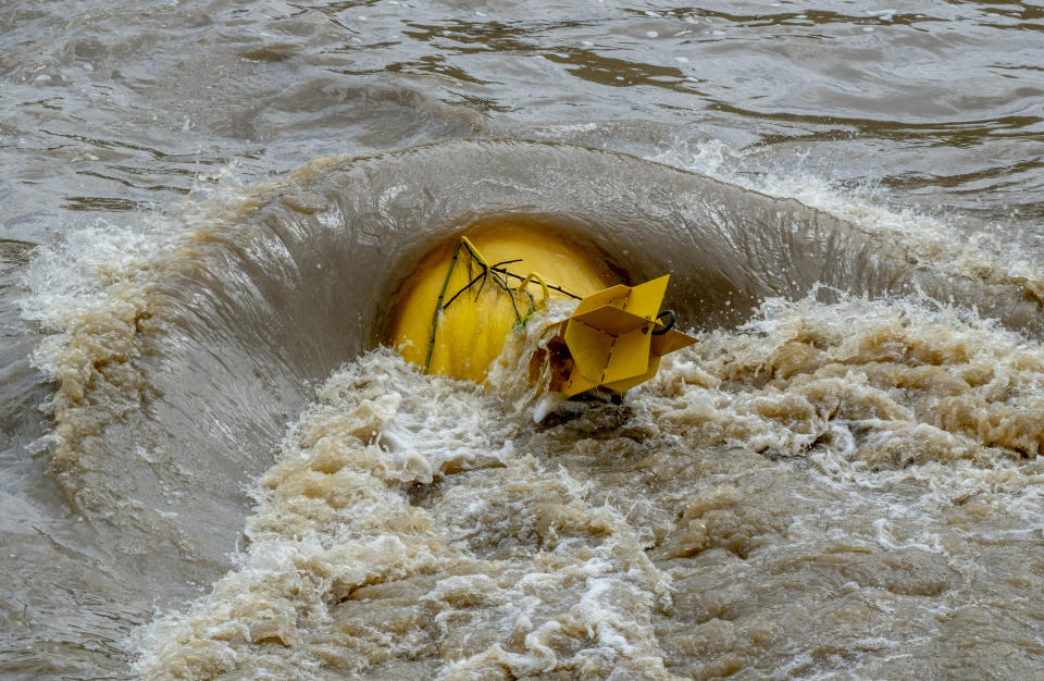 A buoy is pictured as the river Neckar has left its banks in Heidelberg, Germany, Monday, June 3, 2024. Big parts of southern Germany have been flooded after heavy rainfalls during the last days. In background the castle. (AP Photo/Michael Probst)