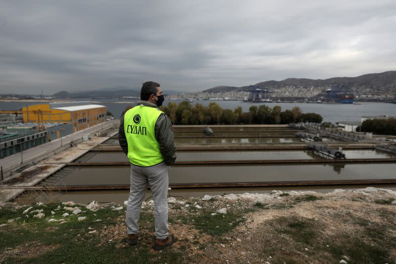 An employee gathers sewage samples at a wastewater treatment plant on the island of Psyttalia