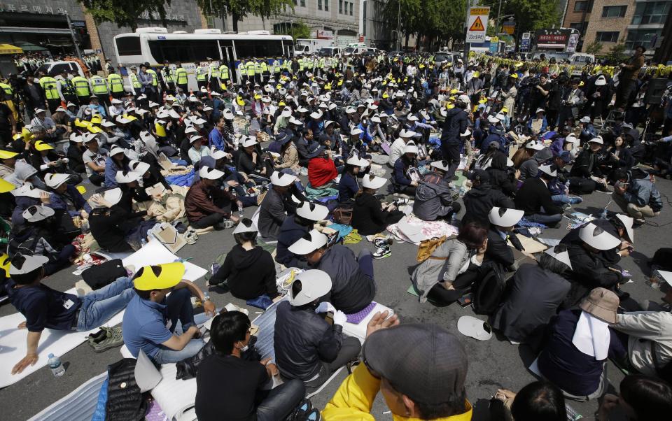 Family members of the victims of the sunken ferry Sewol and citizens sit on a street near the presidential Blue House in Seoul, South Korea, Friday, May 9, 2014. Family members of the victims in the ferry sinking marched to the presidential Blue House in Seoul early Friday calling for a meeting with President Park Geun-hye but ended up sitting on streets near the presidential palace after police officers blocked them. Park's office said a senior presidential official plans to meet them later Friday. (AP Photo/Lee Jin-man)