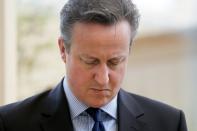 British Prime Minister David Cameron observes a minute's silence during a visit to a Health Centre in his constituency in Witney, England, on July 3, 2015