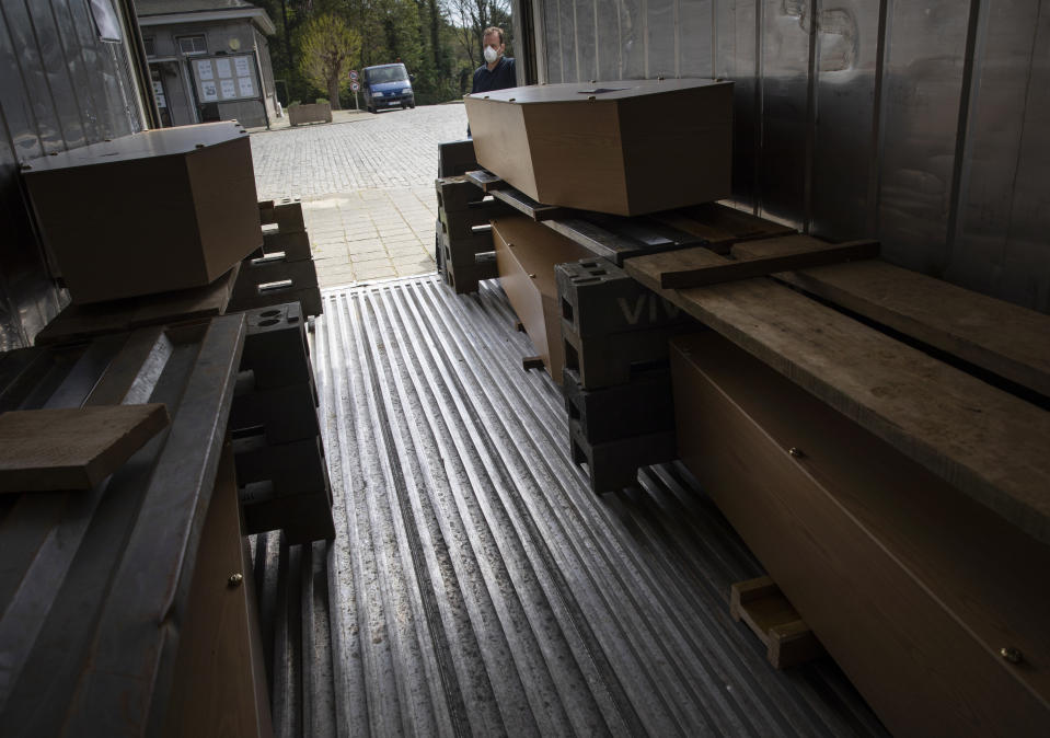 FILE - In this Wednesday, April 15, 2020 file photo, cemetery superintendent David Smedt looks at coffins inside a refrigerated container at the Verrewinkel cemetery in Ukkle, Belgium. This week news struck that the European Center for Disease Control has put Belgium at the largest number of COVID-19 cases per 100,000 citizens, surpassing the Czech Republic, it is revealed Tuesday Oct. 27, 2020. (AP Photo/Virginia Mayo, File)