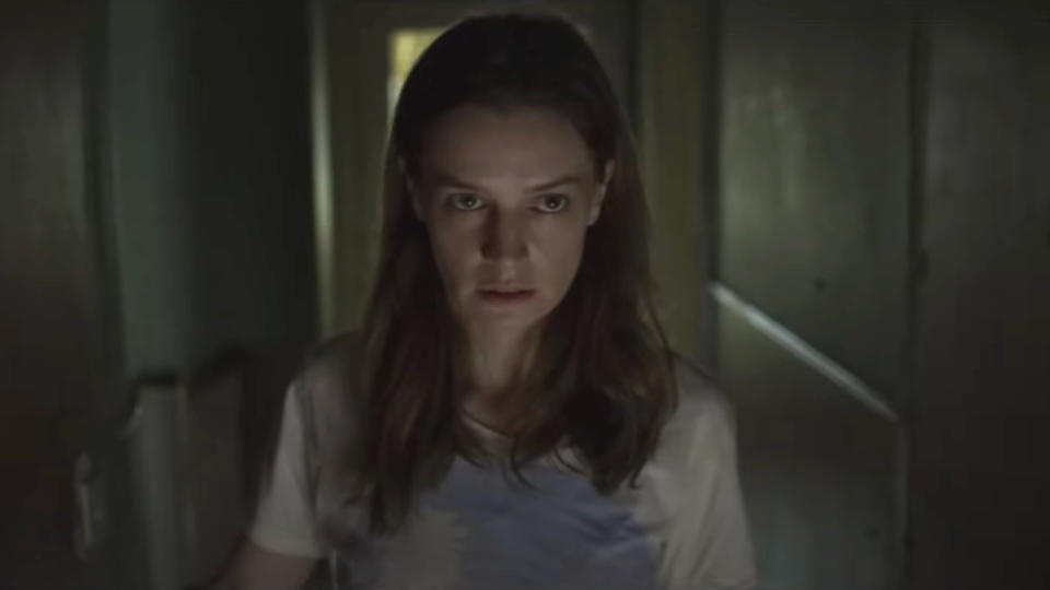 Catherine Walker walks down a dark hallway with caution in A Dark Song.