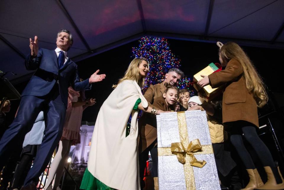 Gov. Gavin Newsom, left, leads a countdown and applause for Layla Datskyy, 8, center, as she lights the tree with help from her father, Alex Datskyy, and First Partner Jennifer Siebel Newsom during the 91st annual state Capitol tree lighting ceremony on Thursday, Dec. 1, 2022, in Sacramento.