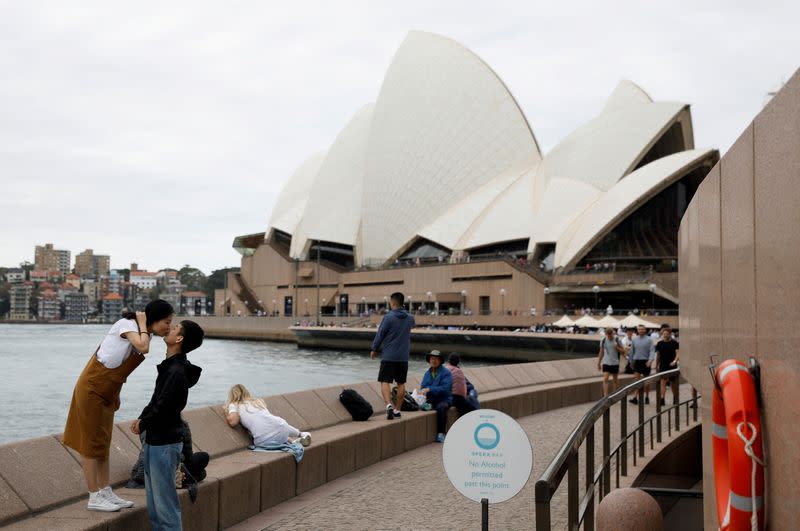 FILE PHOTO: Chinese tourists pose for photographer near the Sydney Opera House