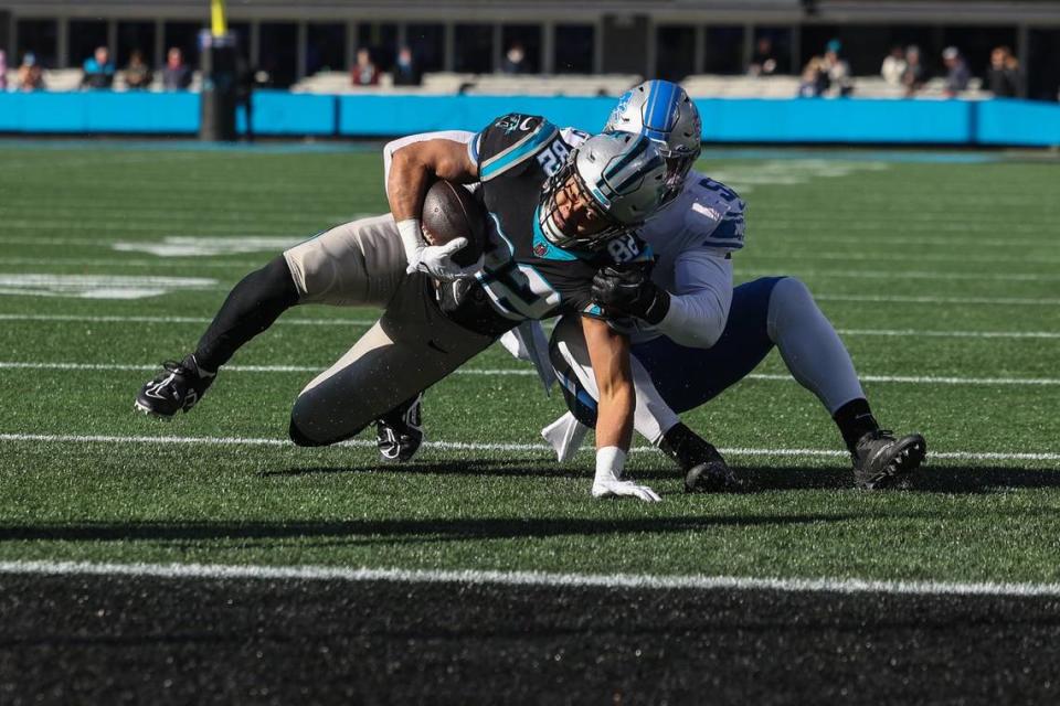 Panthers tight end Tommy Tremble, left, eyes the end zone as he is tackled during the game against the Lions at Bank of America Stadium on Saturday, December 24, 2022.