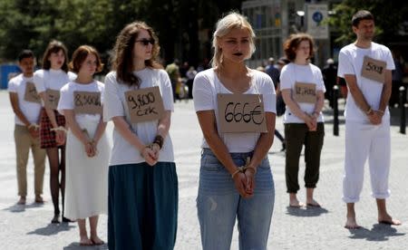 Activists wear price tags as they take part in a flash mob in Prague, Czech Republic, organised by Amnesty International to draw attention to inhuman treatment of migrants in Libya, June 20, 2018. REUTERS/David W Cerny