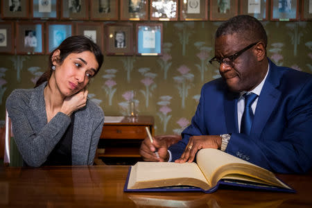 Dr. Denis Mukwege and Nadia Murad sign the Nobel guestbook at a news conference with the 2018 Nobel Laureates at the Nobel Institute in Oslo, Norway December 9, 2018. Heiko Junge/NTB Scanpix/via REUTERS