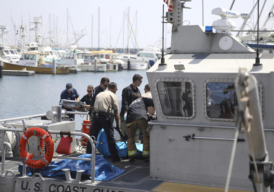 Santa Barbara City Search and Rescue along with Santa Barbara Sheriff officers move a recovered body on the dock at Santa Barbara Harbor in Santa Barbara, Calif., Monday, Sept. 2, 2019. The body was recovered from a dive boat fire near Santa Cruz Island early Monday. (AP Photo/Daniel Dreifuss)