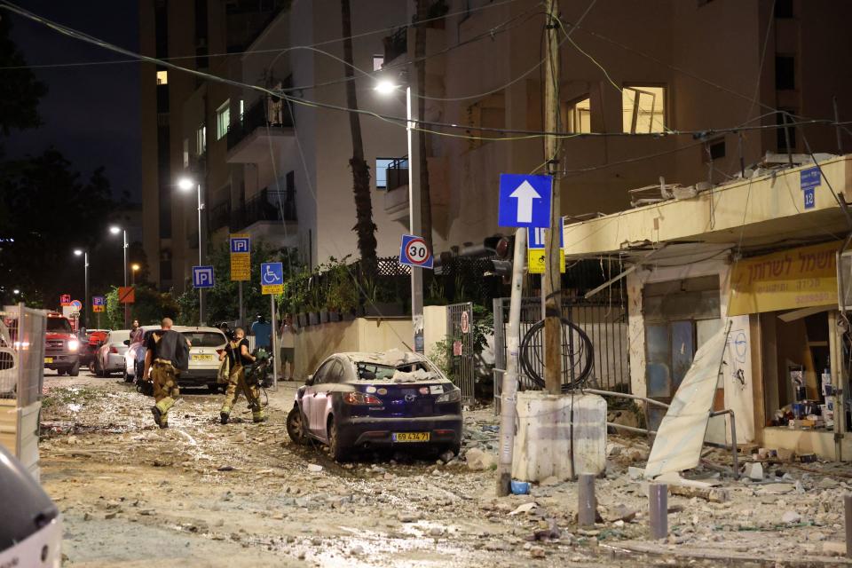 Members of the Israeli security forces walk along a debris-strewn street in Tel Aviv, after it was hit by a rocket fired by Palestinian militants from the Gaza Strip on October 7, 2023. / Credit: JACK GUEZ/AFP via Getty Images