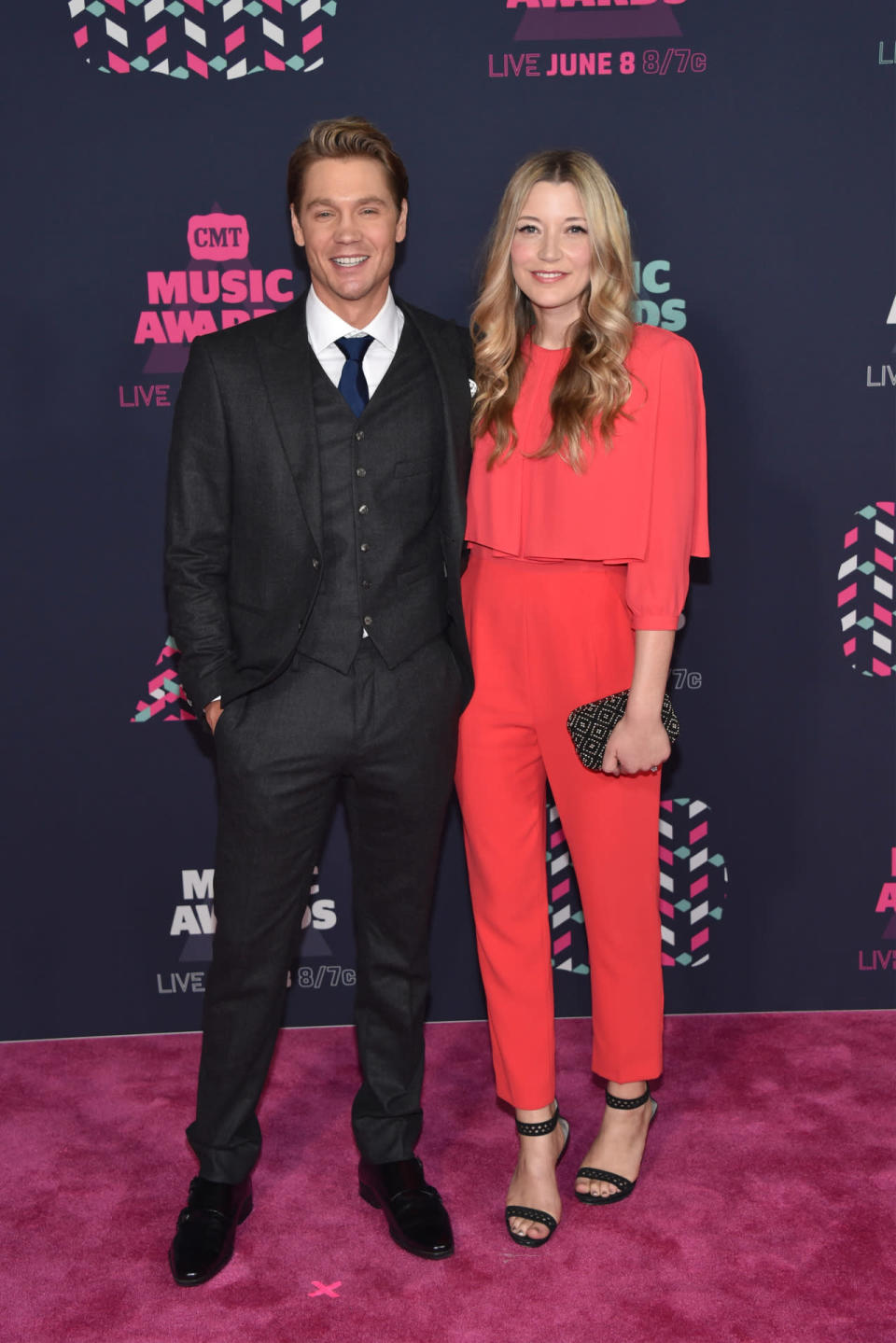 Chad Michael Murray in a three-piece suit with his wife Sarah Roemer wearing a red jumpsuit 