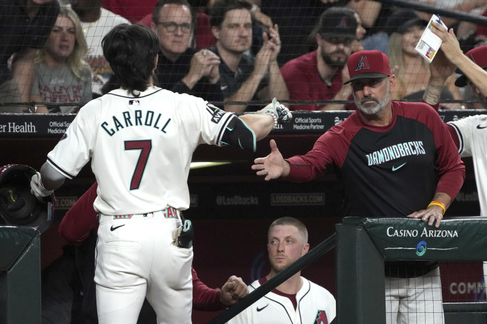 Arizona Diamondbacks' Corbin Carroll (7) celebrates with manager Torey Lovullo, right, after hitting a solo home run against the San Diego Padres in the first inning during a baseball game, Friday, Sept. 27, 2024, in Phoenix. (AP Photo/Rick Scuteri)