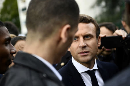 Emmanuel Macron, head of the political movement En Marche !, or Onwards !, and candidate for the 2017 presidential election, speaks with a youth during a campaign visit in Sarcelles, near Paris, April 27, 2017. REUTERS/Martin Bureau/Pool