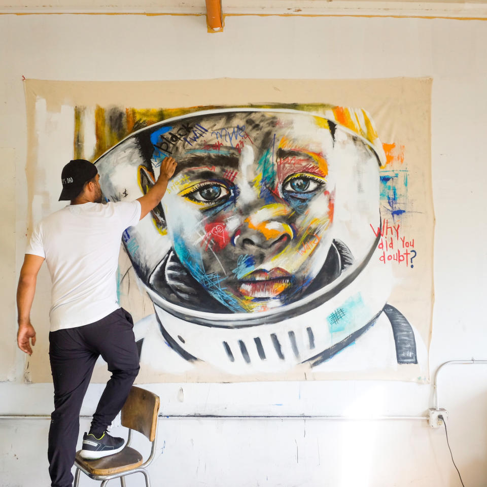 Image: Micah Johnson works on a painting called 