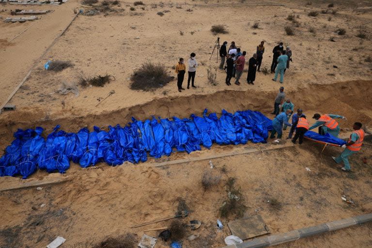 Palestinos entierran cuerpos en una fosa común en el cementerio de Khan Younis, en el sur de la Franja de Gaza, el 22 de noviembre de 2023.