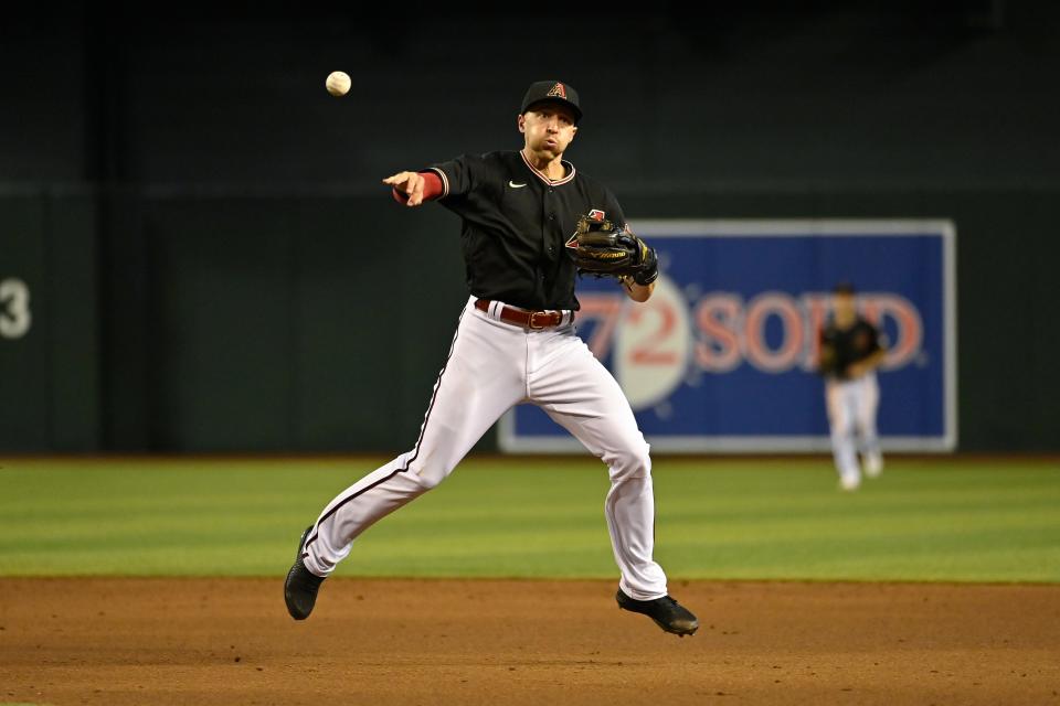 PHOENIX, ARIZONA - MAY 14: Infielder Nick Ahmed #13 of the Arizona Diamondbacks throws to first base during the sixth inning of the MLB game against the Chicago Cubs at Chase Field on May 14, 2022 in Phoenix, Arizona. (Photo by Kelsey Grant/Getty Images)