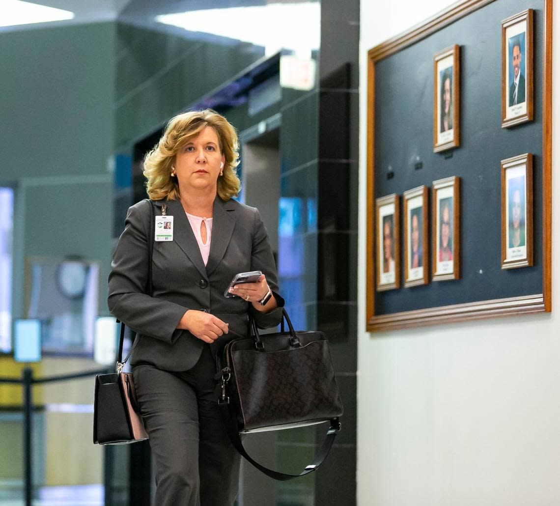 Broward Schools Superintendent Vickie Cartwright exits the Kathleen C. Wright Administration Center on Friday, Aug. 26, after Gov. Ron DeSantis suspended four Broward County School Board members. Cartwright makes her way past a bulletin board displaying only the five remaining members.