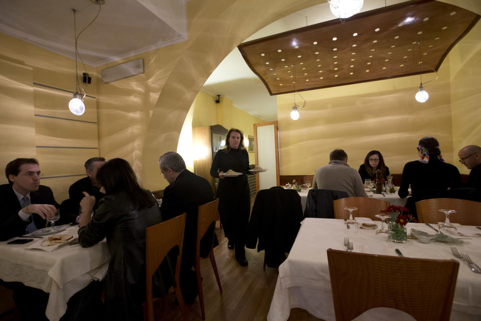 Restaurant owner Patrizia Podetti, center, serves dishes in her Velando restaurant, in Rome, Monday, March 18, 2013. Velando is a favorite dining spot for churchmen, with sleek wooden furnishings, subdued lighting and vaulted, whitewashed ceiling giving an air of a church sacristy. Joseph Ratzinger, recently retired Pope Benedict XVI, often dined there before becoming pope. (AP Photo/Andrew Medichini)