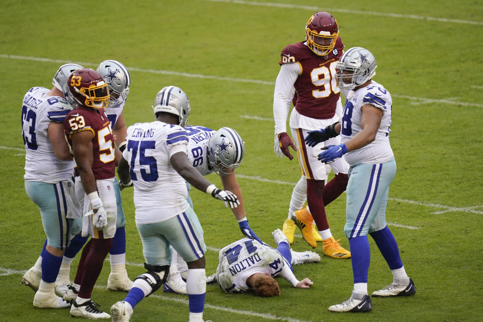 Dallas Cowboys quarterback Andy Dalton (14) lies on the ground after getting hit by Washington Football Team inside linebacker Jon Bostic (53) in the second half of an NFL football game, Sunday, Oct. 25, 2020, in Landover, Md. (AP Photo/Patrick Semansky)