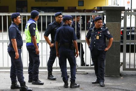 Malaysian police officers gather in front of the gate of the morgue at Kuala Lumpur General Hospital where Kim Jong Nam's body is held for autopsy in Malaysia February 21, 2017. REUTERS/Athit Perawongmetha