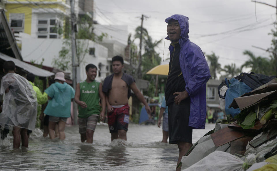Residents wade along a flooded village caused by typhoon Vongfong as it passed by Sorsogon province, eastern Philippines on Friday May 15, 2020. More than 150,000 people were riding out a weakening typhoon in emergency shelters in the Philippines on Friday after a mass evacuation that was complicated and slowed by the coronavirus. (AP Photo/Melchor Hilotin)